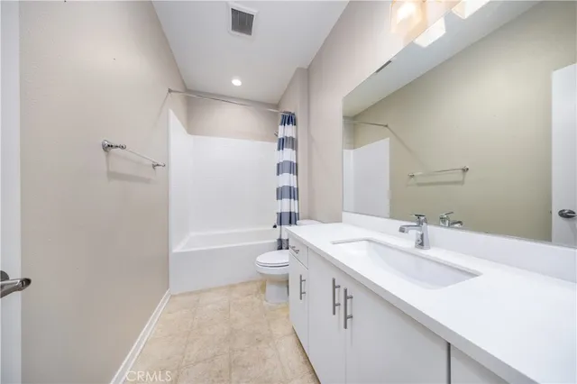 a bathroom with a sink a toilet a mirror and shower