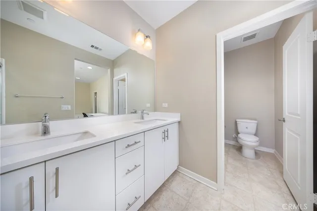 a bathroom with a granite countertop sink mirror and toilet