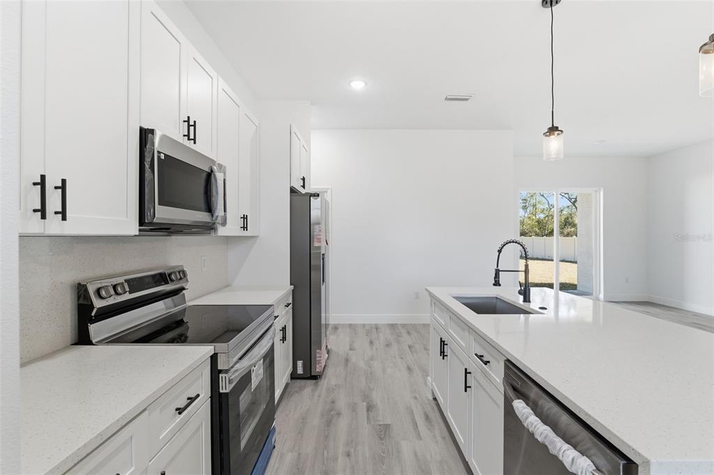 4473 Southwest 168th Lane Ocala, FL 34473 - Photo 13 of 33 a kitchen with stainless steel appliances a stove microwave and refrigerator