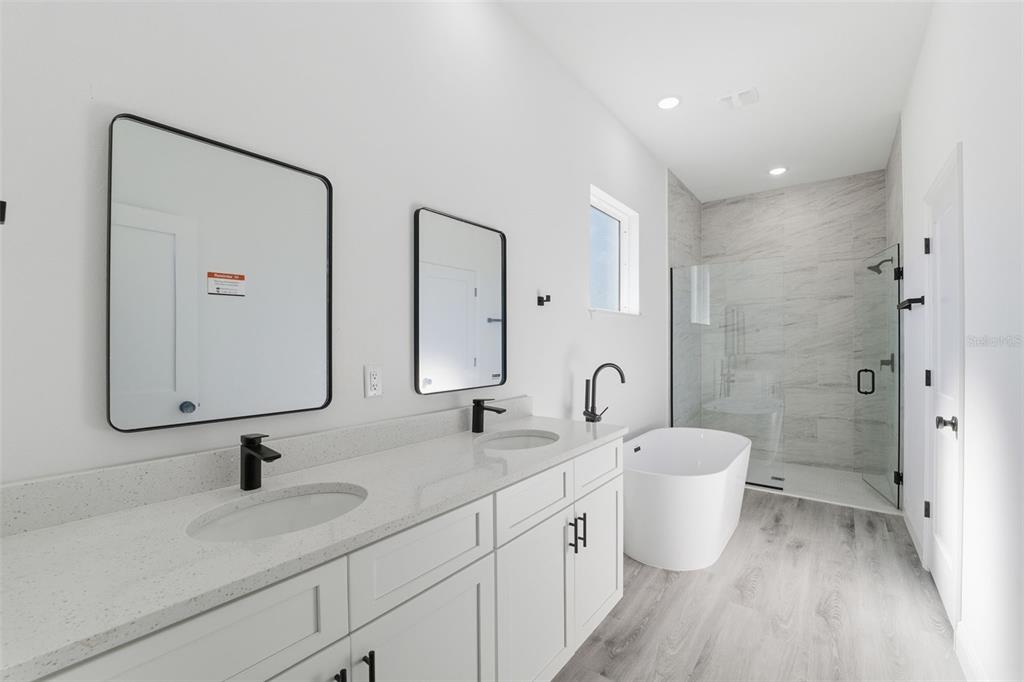 4473 Southwest 168th Lane Ocala, FL 34473 - Photo 17 of 33 a bathroom with a double vanity sink toilet mirror and shower