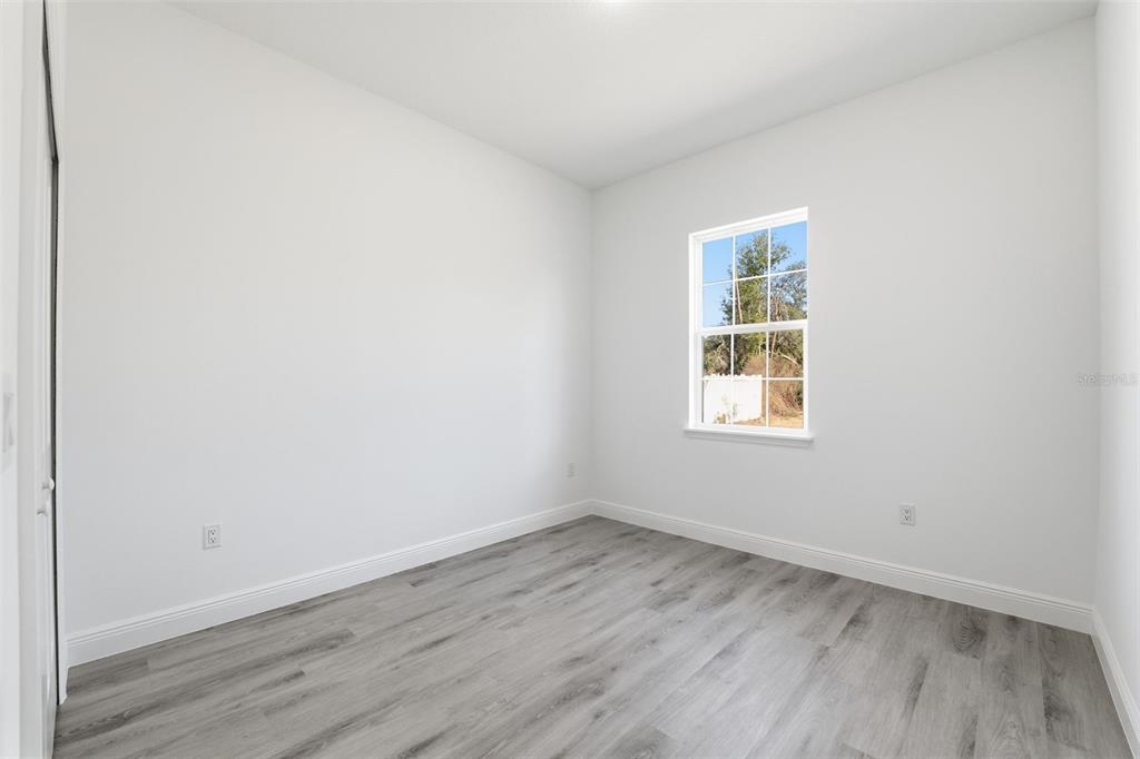 4473 Southwest 168th Lane Ocala, FL 34473 - Photo 23 of 33 an empty room with wooden floor and window