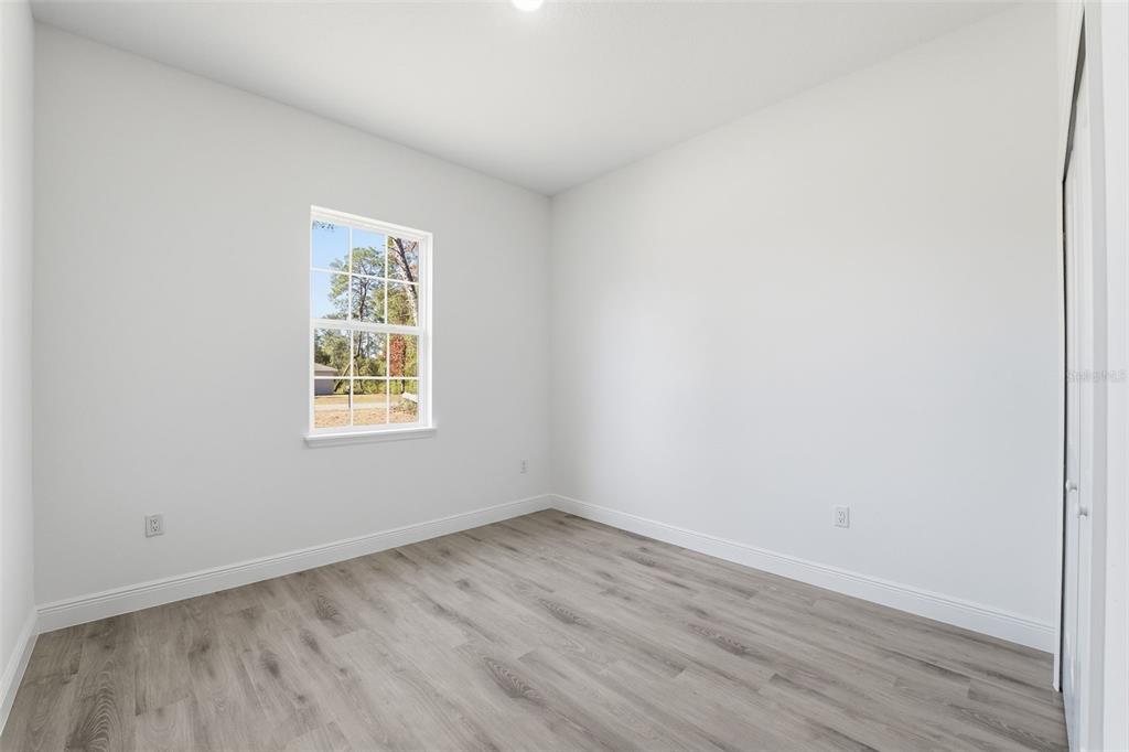 4473 Southwest 168th Lane Ocala, FL 34473 - Photo 26 of 33 an empty room with wooden floor and windows