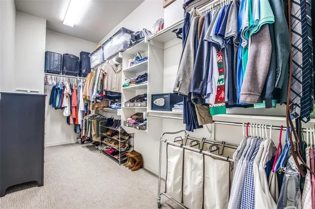 a view of walk in closet with clothes and shoes