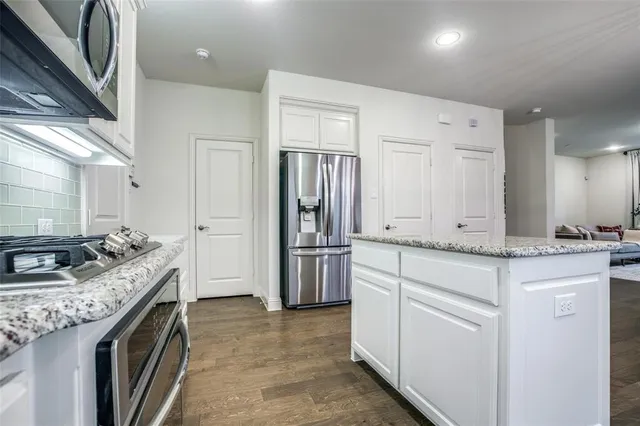 a kitchen with stainless steel appliances granite countertop a stove a refrigerator and a refrigerator