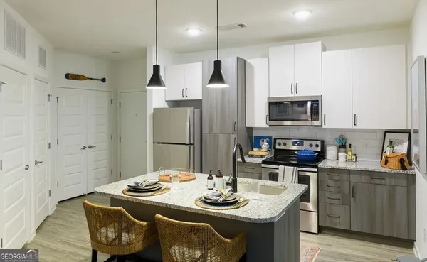 a kitchen with stainless steel appliances kitchen island granite countertop a sink a refrigerator and a stove