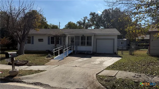 front view of a house with a yard and trees