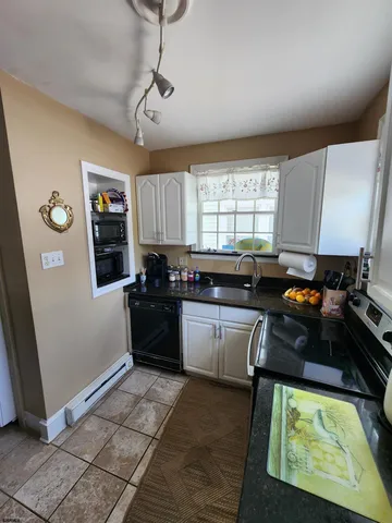 a kitchen with a refrigerator a sink a window and cabinets