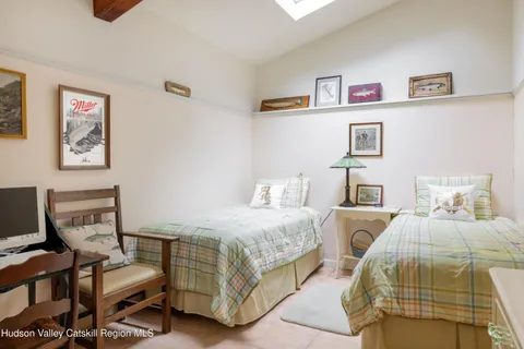 a bedroom with two beds and painting on the wall