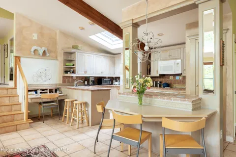 a kitchen with kitchen island granite countertop a table chairs sink and cabinets