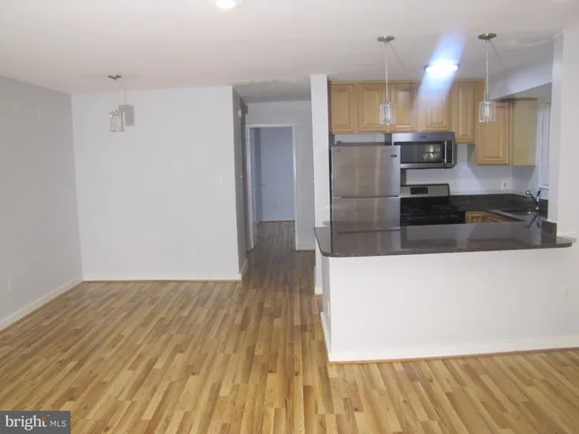 a large kitchen with cabinets and wooden floor