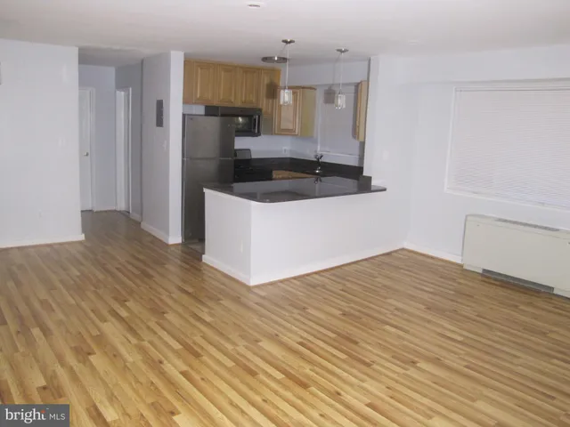 a kitchen with a refrigerator and a stove top oven