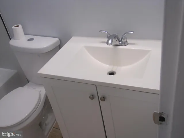 a bathroom with a sink mirror and toilet