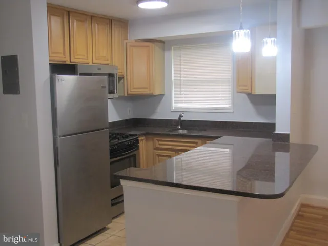 a kitchen with granite countertop a refrigerator and a sink