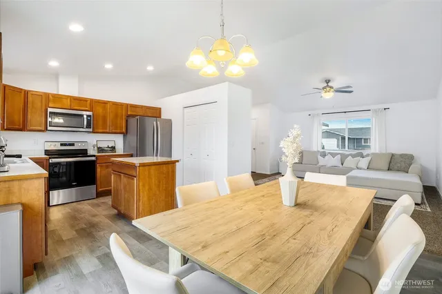 a kitchen with a table chairs microwave and refrigerator