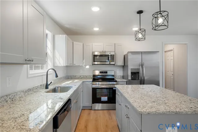 a kitchen with stainless steel appliances granite countertop a sink stove and refrigerator