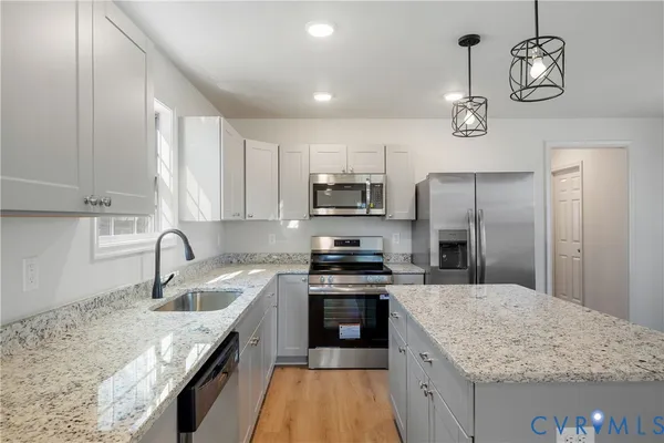 a kitchen with stainless steel appliances granite countertop a sink stove and refrigerator
