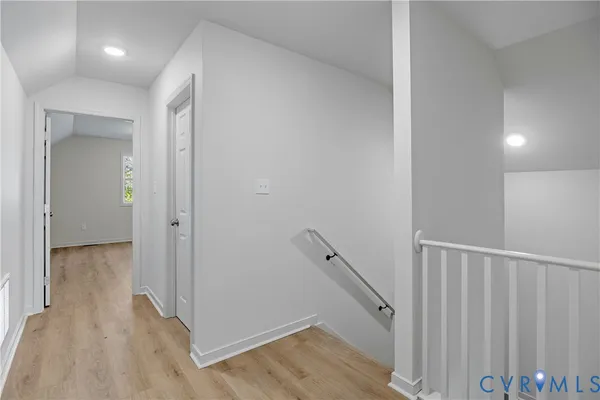 a view of a hallway with wooden floor and staircase