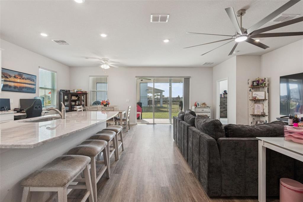 11965 Muskegon Court Parrish, FL 34219 - Photo 11 of 74 a large living room with stainless steel appliances granite countertop a couch and a view of living room