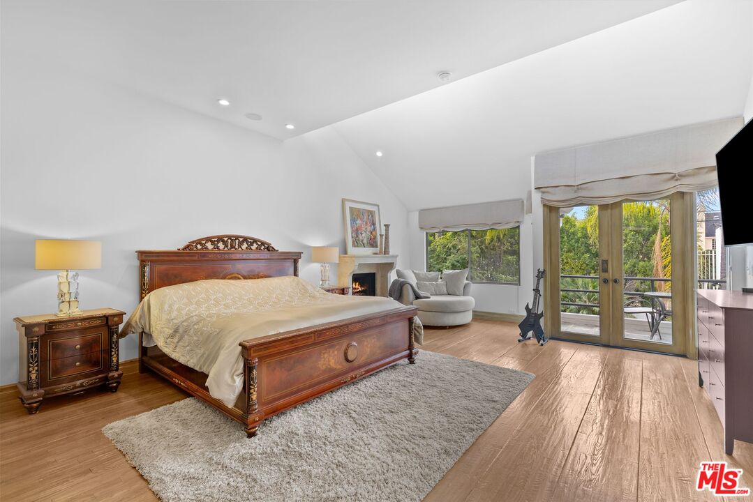 605 North Hillcrest Road Beverly Hills, CA 90210 - Photo 17 of 36 a bedroom with a bed and large windows