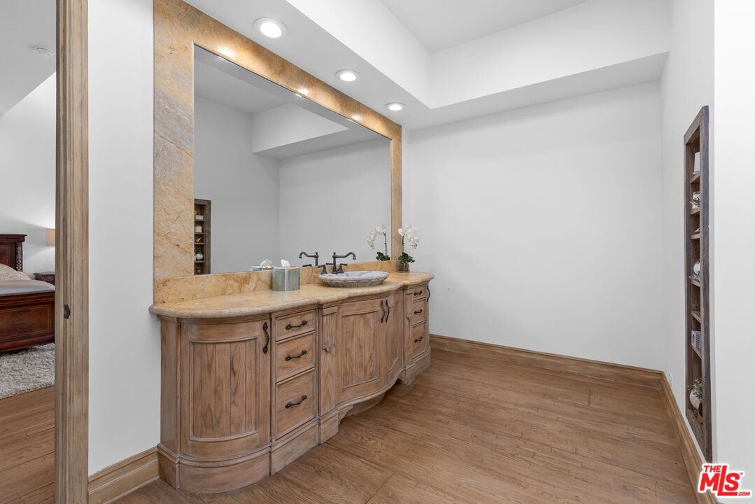 605 North Hillcrest Road Beverly Hills, CA 90210 - Photo 18 of 36 a spacious bathroom with a granite countertop double vanity and a mirror