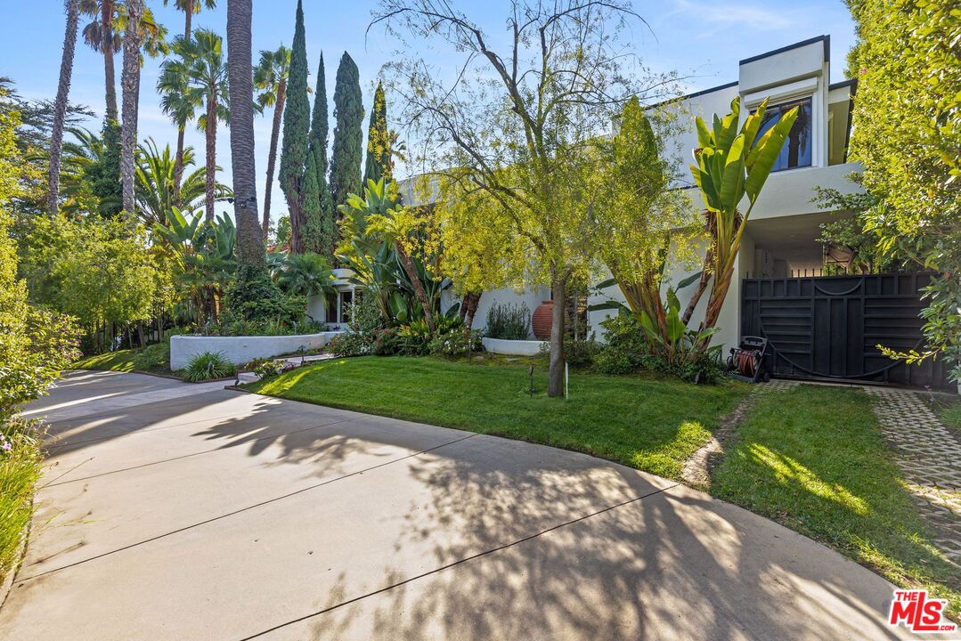 605 North Hillcrest Road Beverly Hills, CA 90210 - Photo 2 of 36 a view of a backyard with plants and palm trees