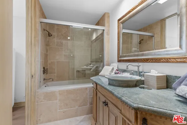 a bathroom with a granite countertop sink a toilet and shower