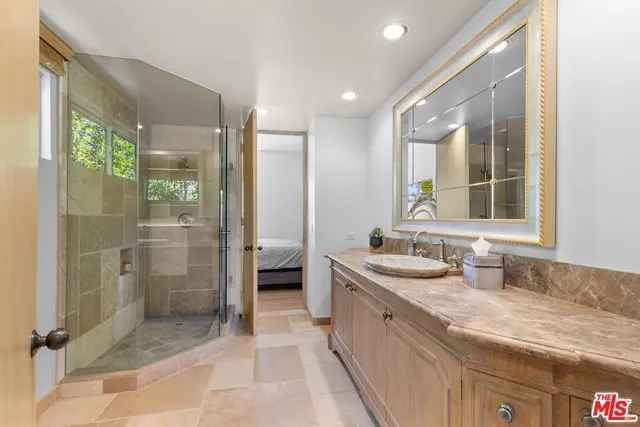 a bathroom with a granite countertop sink mirror and shower
