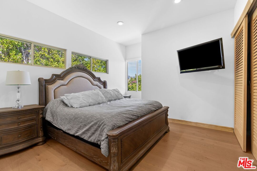 605 North Hillcrest Road Beverly Hills, CA 90210 - Photo 25 of 36 a bedroom with a bed and a flat screen tv