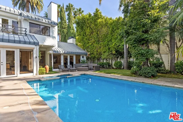 a front view of a house with swimming pool and porch with furniture