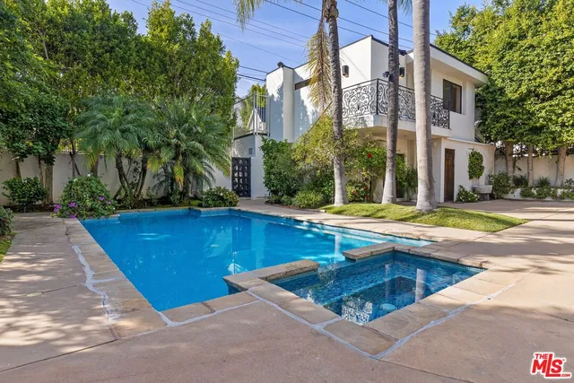 a view of swimming pool with outdoor seating and house in the background