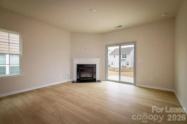 a view of an empty room with a window and fireplace