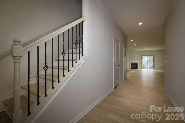 a view of a hallway with wooden floor and staircase