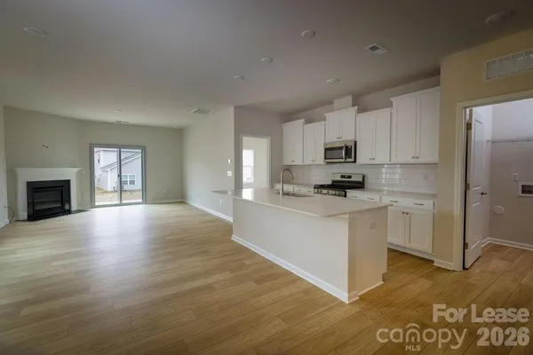 a kitchen with granite countertop a refrigerator stove top oven and cabinets