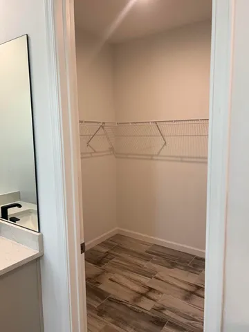 a view of a hallway with wooden floor and closet area