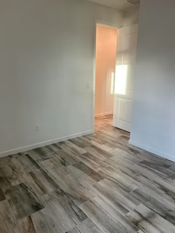 a view of a room with wooden floor and window