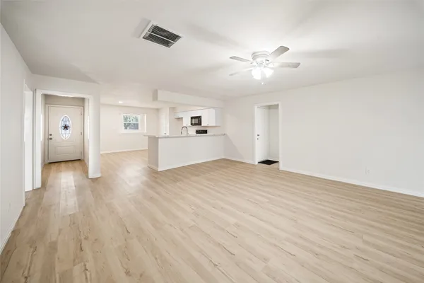 a view of empty room with wooden floor