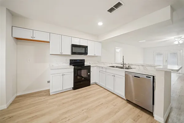 a kitchen with white cabinets and appliances