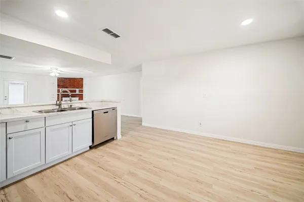 a kitchen with a sink cabinets and wooden floor
