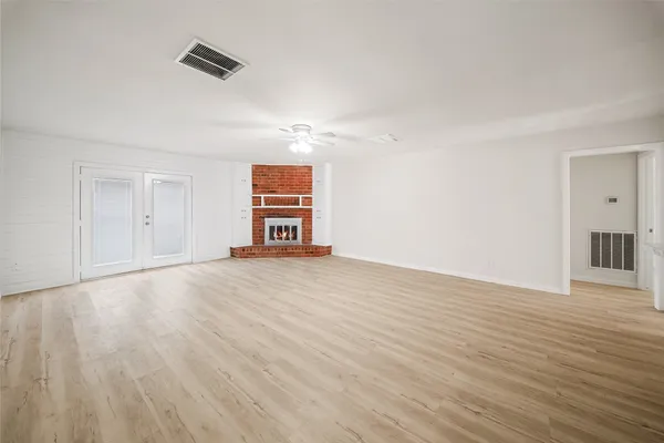 a view of empty room with wooden floor and appliances
