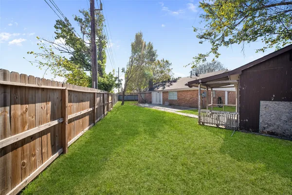 a view of a backyard with table and chairs and a tree