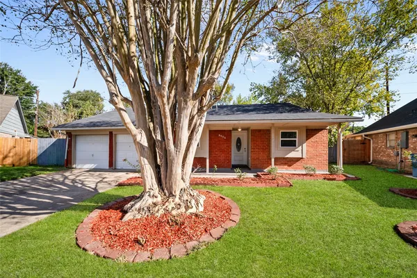 a front view of a house with a yard and trees