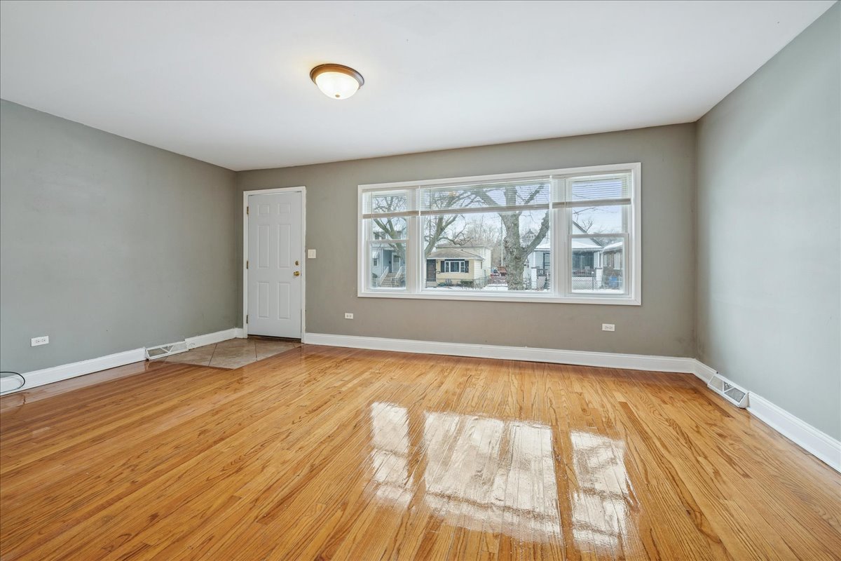 11709 South Peoria Street Chicago, IL 60643 - Photo 2 of 15 a view of an empty room with wooden floor and a window