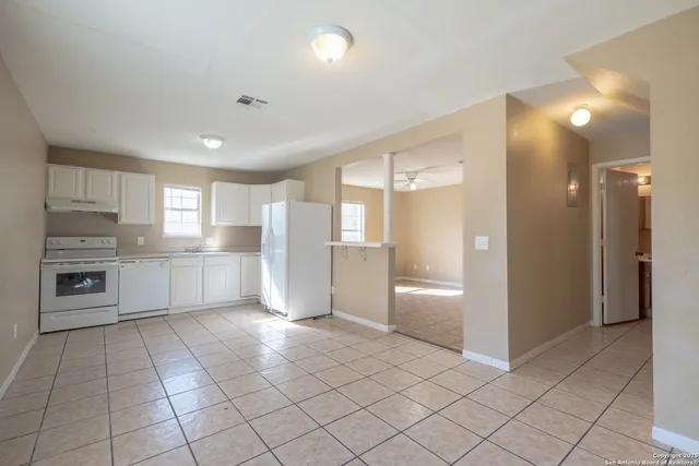 a view of a kitchen with a refrigerator and a stove top oven