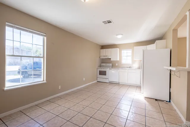 a kitchen with white cabinets and white appliances