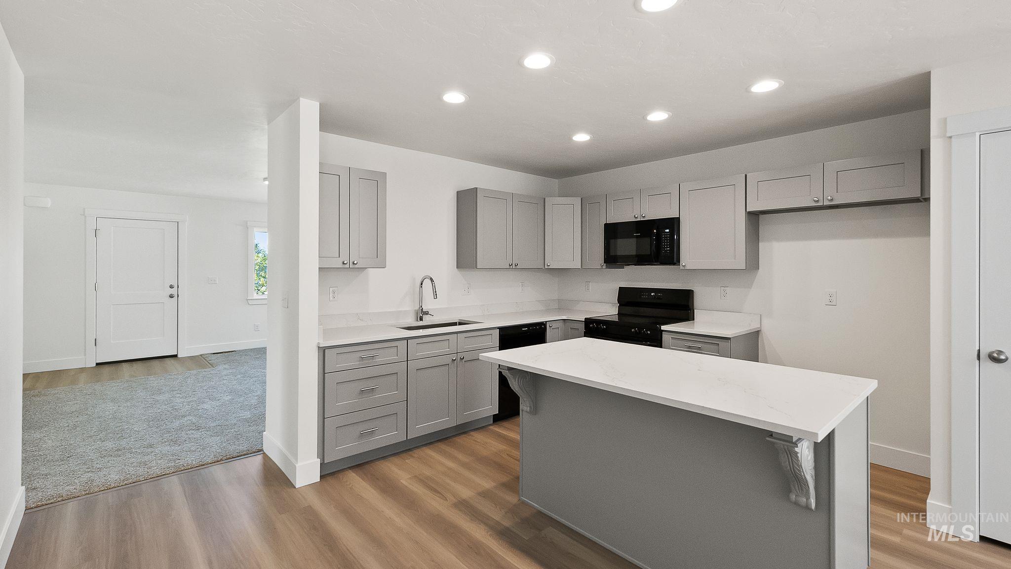 1440 Castle Way Emmett, ID 83617 - Photo 11 of 30 Kitchen with gray cabinets, black appliances, light wood-style flooring, and recessed lighting