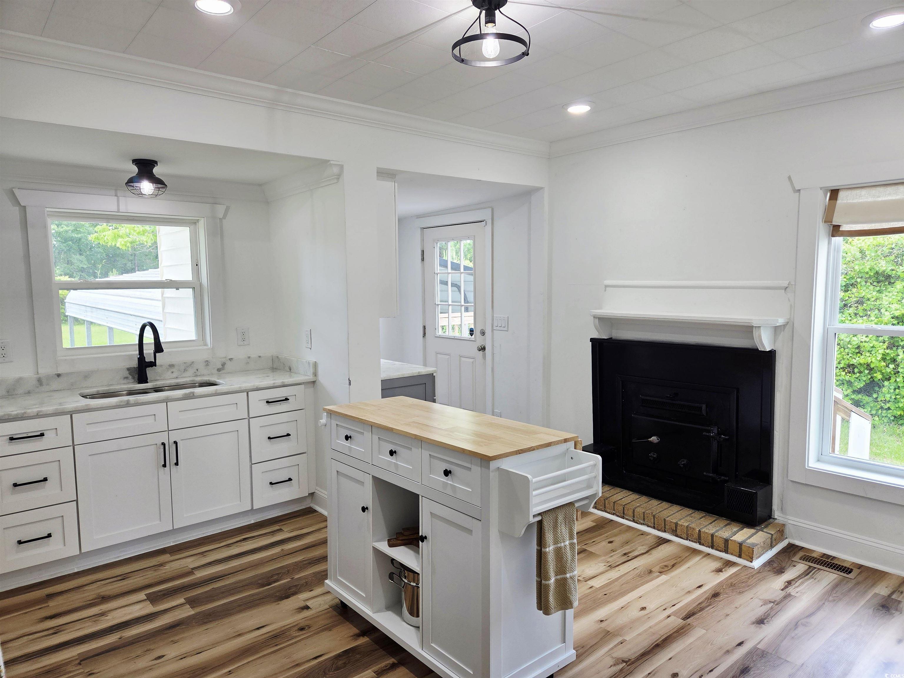 675 Liberty Church Road Loris, SC 29569 - Photo 19 of 35 Kitchen with ornamental molding, wooden counters, visible vents, a sink, and wood finished floors