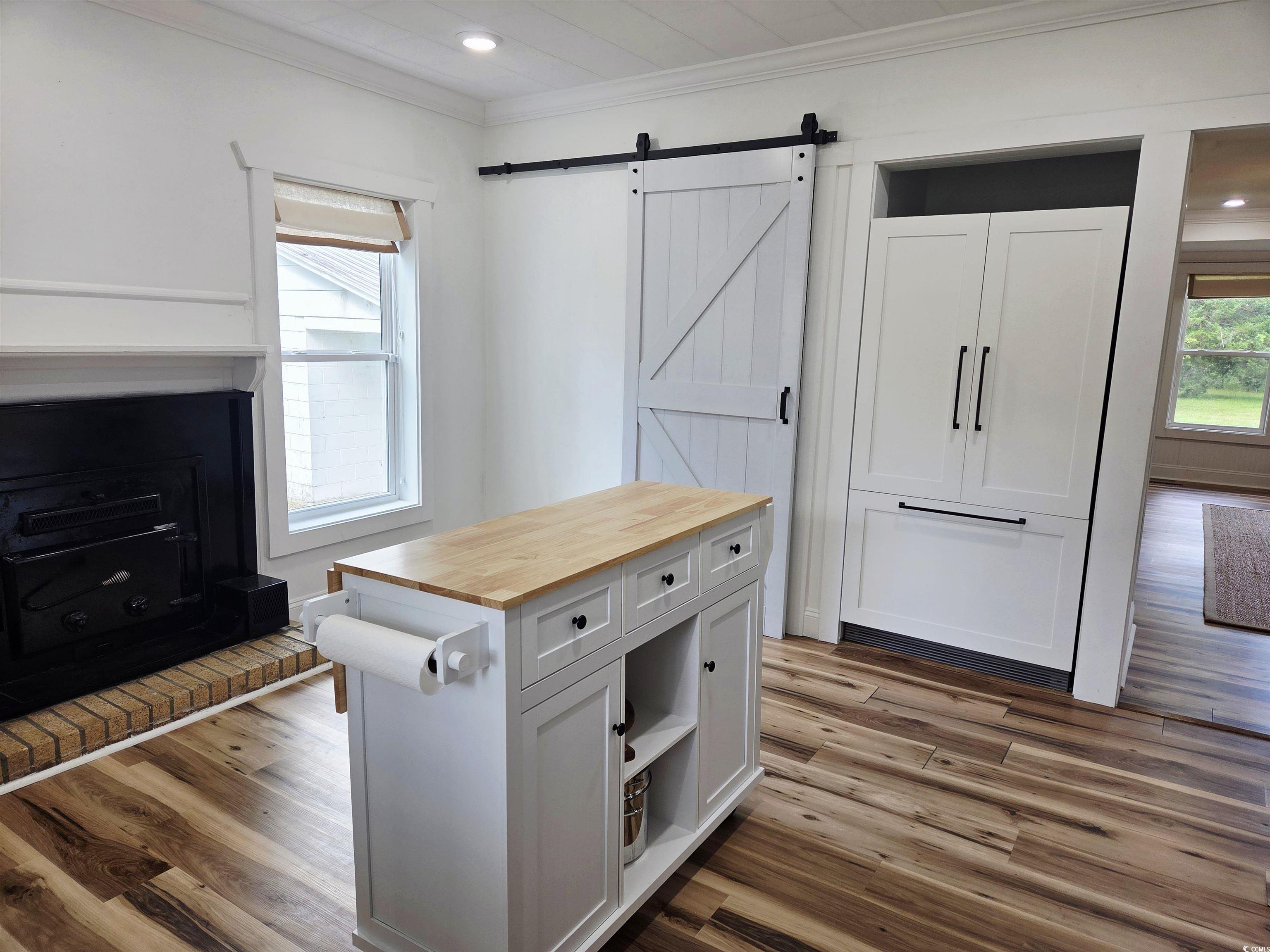 675 Liberty Church Road Loris, SC 29569 - Photo 20 of 35 Interior space featuring a barn door, butcher block counters, crown molding, and dark wood-type flooring