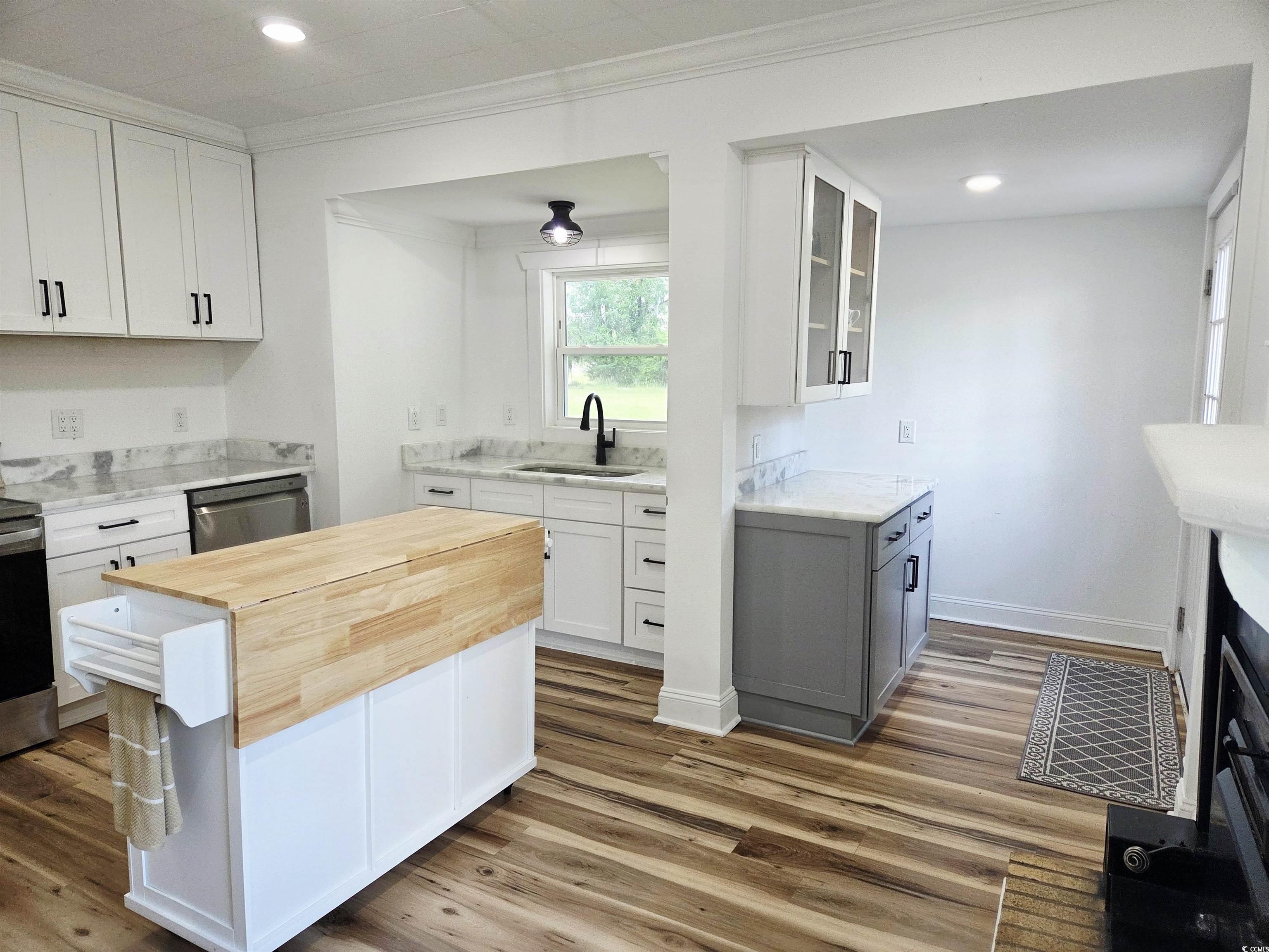 675 Liberty Church Road Loris, SC 29569 - Photo 21 of 35 Kitchen with appliances with stainless steel finishes, wooden counters, wood finished floors, and a sink