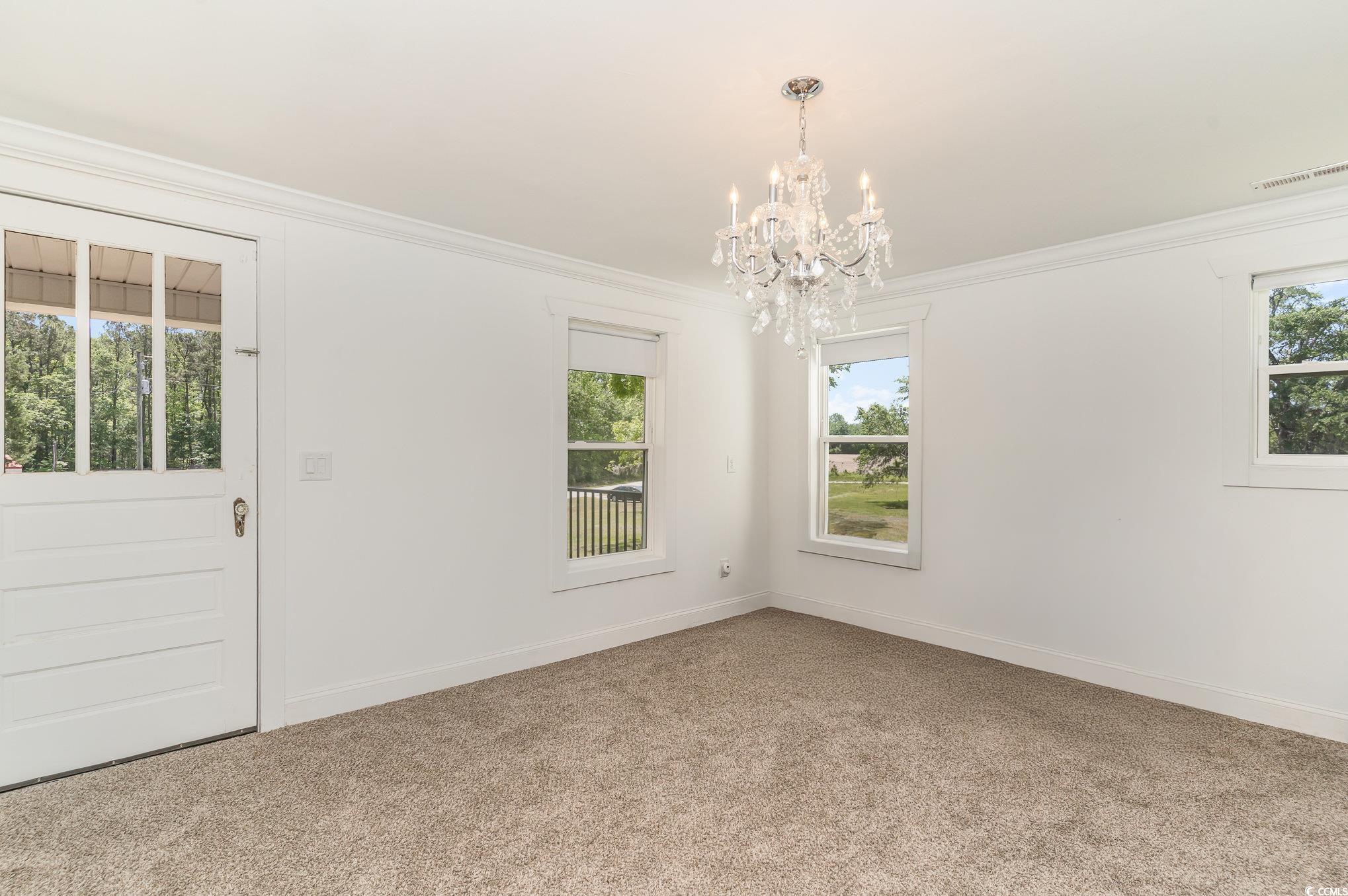 675 Liberty Church Road Loris, SC 29569 - Photo 34 of 35 Spare room with a notable chandelier, carpet, baseboards, visible vents, and crown molding