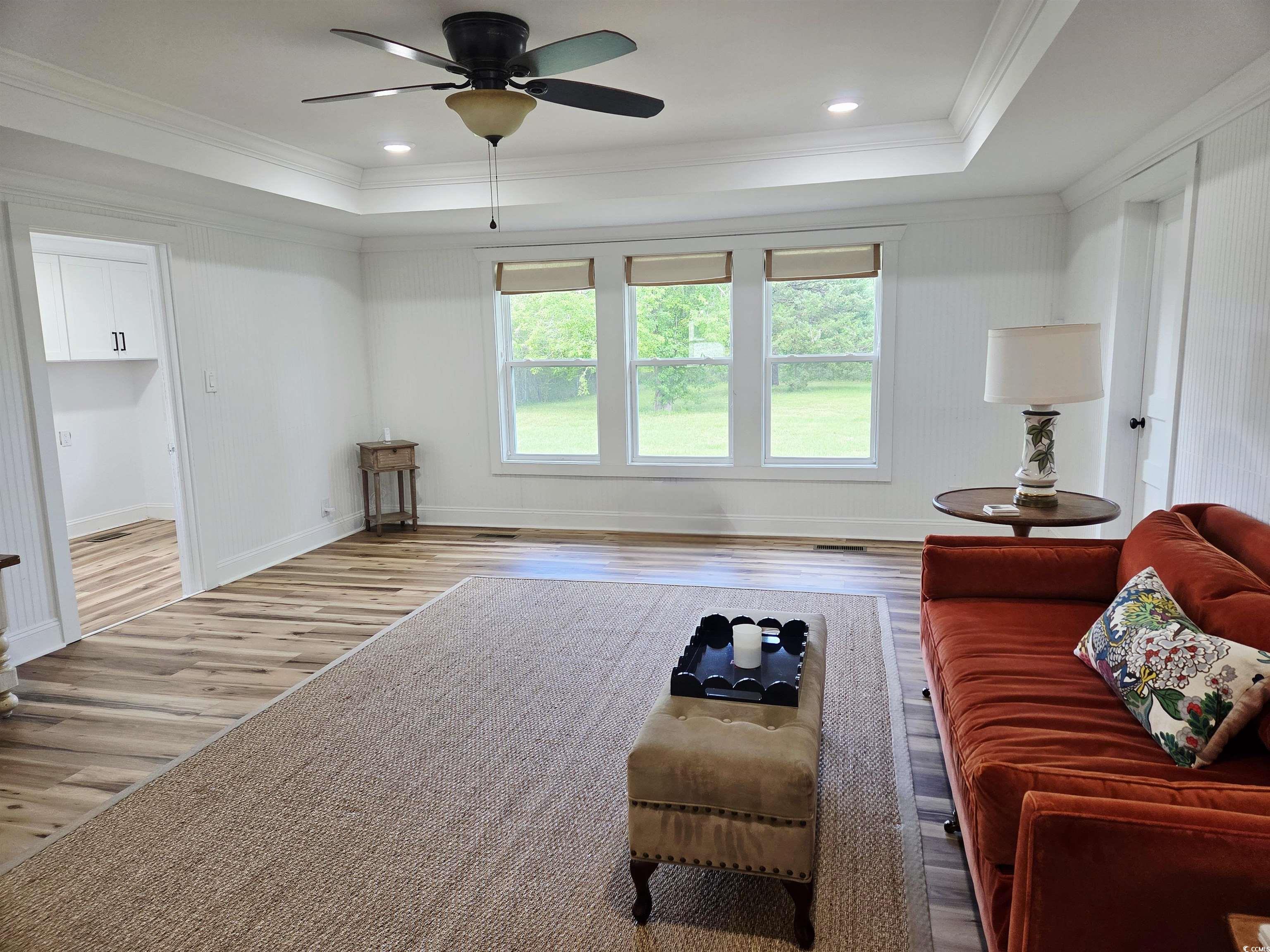 675 Liberty Church Road Loris, SC 29569 - Photo 10 of 35 Living room featuring ceiling fan, wood finished floors, a raised ceiling, and ornamental molding